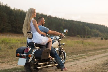 Bir motosiklet üzerinde bir alanda genç Romantik Çift