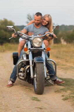 Bir motosiklet üzerinde bir alanda genç Romantik Çift