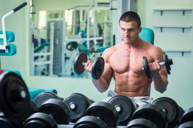 Spor salonunda yakışıklı, atletik, kendine güvenen adam. vücut geliştirme poz