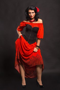 Görüntü, şık ve seksi İspanyol. Kırmızı bir elbise şık ve seksi kadın. Güzel esmer kırmızı stüdyoda portresi. Duygusal portre.