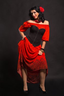 Görüntü, şık ve seksi İspanyol. Kırmızı bir elbise şık ve seksi kadın. Güzel esmer kırmızı stüdyoda portresi. Duygusal portre.