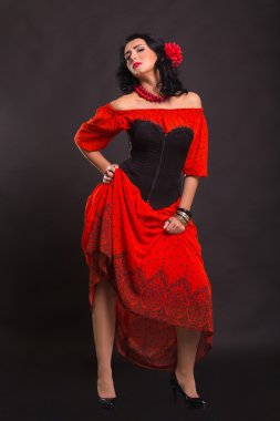 Görüntü, şık ve seksi İspanyol. Kırmızı bir elbise şık ve seksi kadın. Güzel esmer kırmızı stüdyoda portresi. Duygusal portre.
