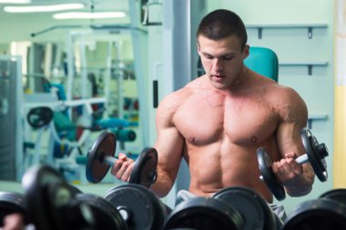 Spor salonunda yakışıklı, atletik, kendine güvenen adam. vücut geliştirme poz