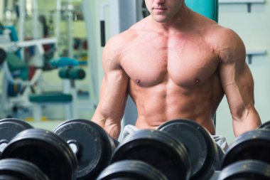 Spor salonunda yakışıklı, atletik, kendine güvenen adam. vücut geliştirme poz