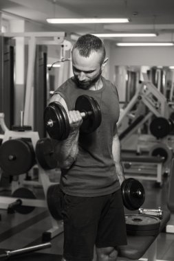 Vücut geliştirme dumbbells ile. Husky büyük bir dumbbell elinde tutar. Spor, vücut geliştirme, sağlıklı yaşam tarzı.