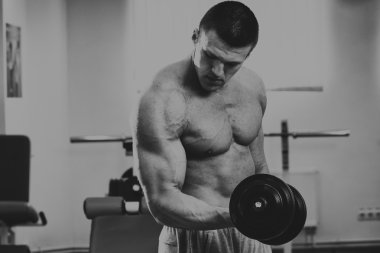 Spor salonunda yakışıklı, atletik, kendine güvenen adam. vücut geliştirme poz