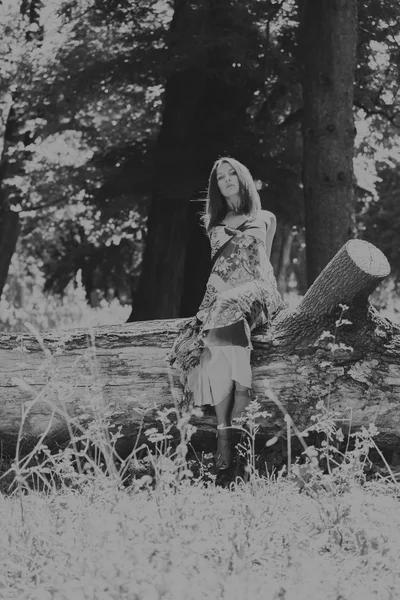 Foto menina bonita no parque. Um jovem vestido morena no meio de delicadas flores silvestres. Retrato foto em preto e branco de uma menina com maquiagem profissional . — Fotografia de Stock