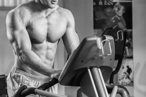 Strong muscular man on a treadmill. — Stock Photo, Image
