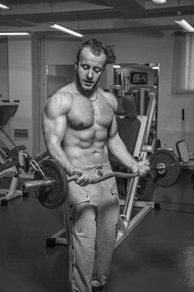 重量在健身房锻炼的肌肉男。人做练习. — 图库照片