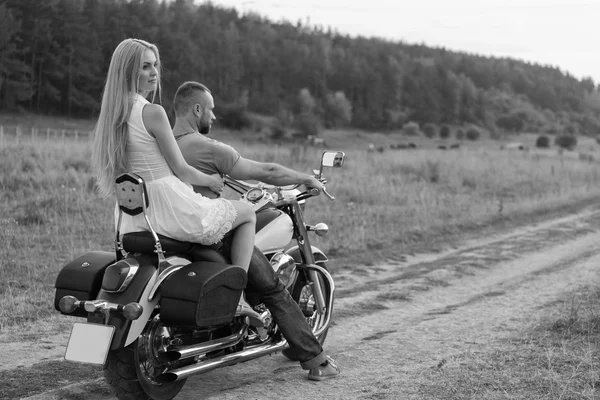 Jeunes mariés au milieu du terrain sur une route de moto. Joyeux couple voyageant en moto. Une vie extraordinaire. Photo en noir et blanc pour les réseaux sociaux et les sites web magazines de motos . — Photo