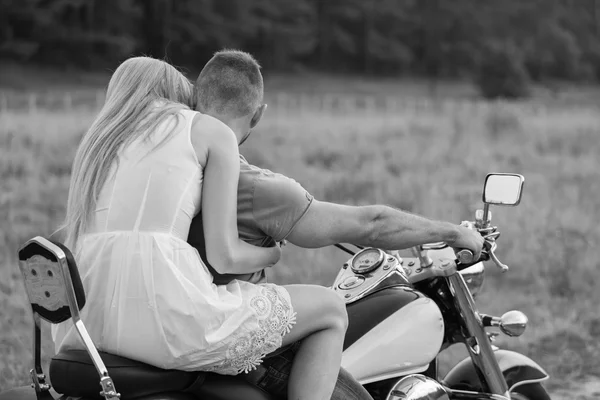 Jonggehuwden midden van het veld op een motorfiets weg. Gelukkige paar reizen op een motorfiets. Buitengewone leven. Zwart-wit foto voor sociale en posters en websites motorfiets tijdschriften. — Stockfoto