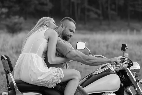 オートバイの道にフィールドの真ん中で新婚夫婦。幸せなカップルがバイクに旅行します。非凡な人生。社会のモノクロ写真とポスターやウェブサイトのオートバイ雑誌. — ストック写真