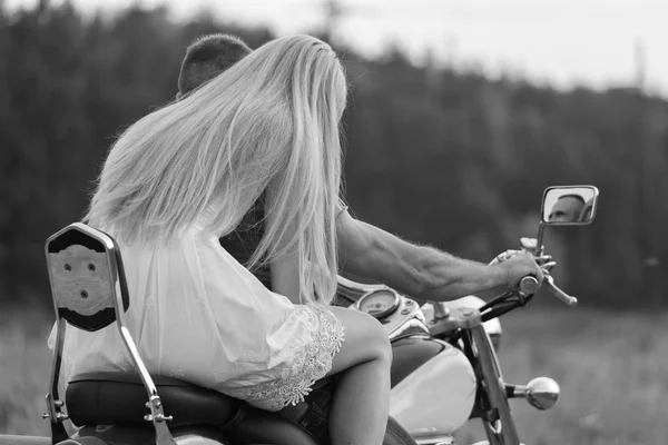 Nygifta mitten av fältet på en motorcykel road. Lyckliga par reser på en motorcykel. Extra liv. Svartvitt fotografi för sociala och affischer och webbplatser MC-tidningar. — Stockfoto