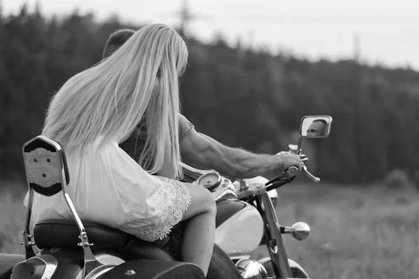 Frischvermählte mitten im Feld auf einer Motorradstraße. glückliches Paar, das auf einem Motorrad unterwegs ist. außergewöhnliches Leben. Schwarz-Weiß-Foto für soziale Medien, Plakate und Webseiten von Motorradzeitschriften. — Stockfoto