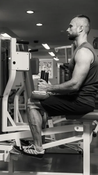 Hombre haciendo ejercicios de piernas, ejercicios en el simulador. Deportes, estilo de vida saludable . — Foto de Stock