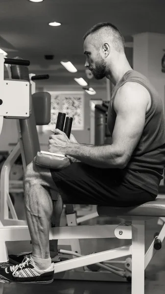Hombre haciendo ejercicios de piernas, ejercicios en el simulador. Deportes, estilo de vida saludable . — Foto de Stock