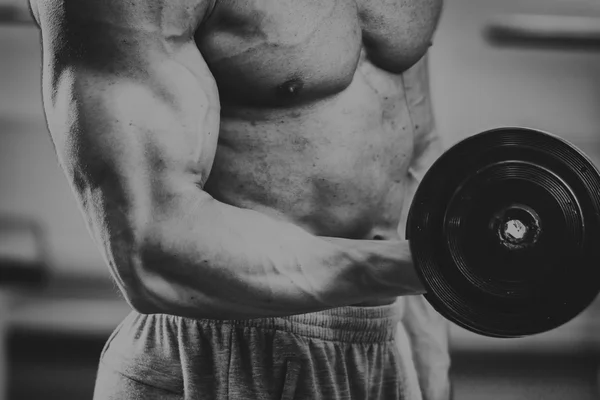 Sterke gespierde man doen oefeningen in de sportschool. — Stockfoto