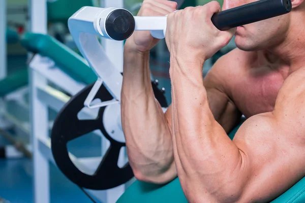 Forte uomo muscolare che fa esercizi in palestra . — Foto Stock