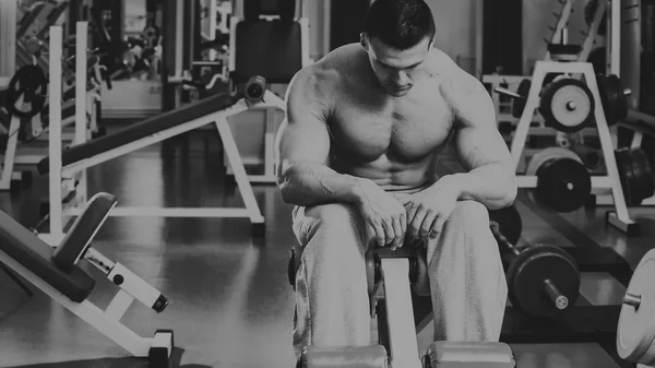 Sterke gespierde man doen oefeningen in de sportschool. — Stockfoto