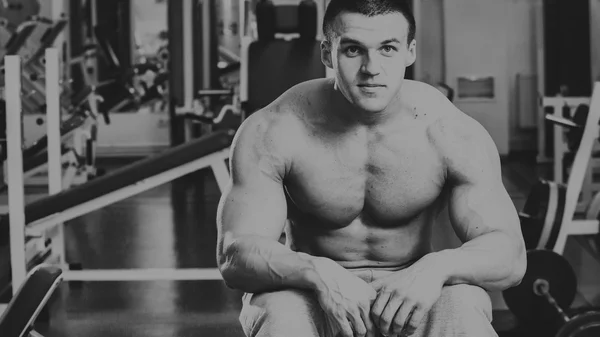 Strong muscular man doing exercises in the gym. — Stock Photo, Image