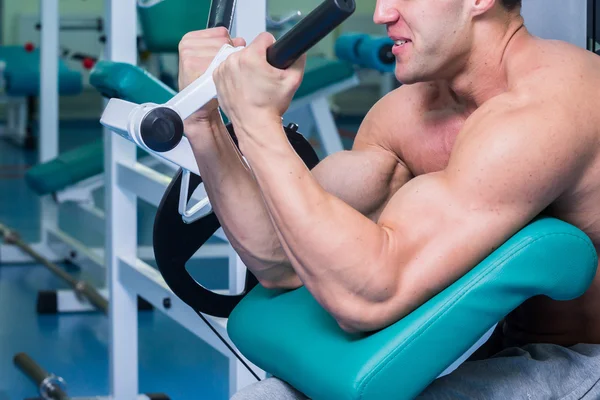 Forte uomo muscolare che fa esercizi in palestra . — Foto Stock