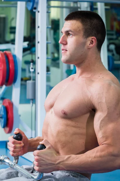 Starker muskulöser Mann bei Übungen im Fitnessstudio. — Stockfoto