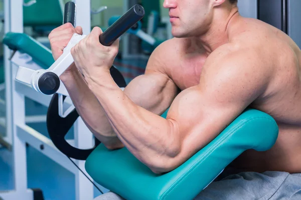 Starker muskulöser Mann bei Übungen im Fitnessstudio. — Stockfoto