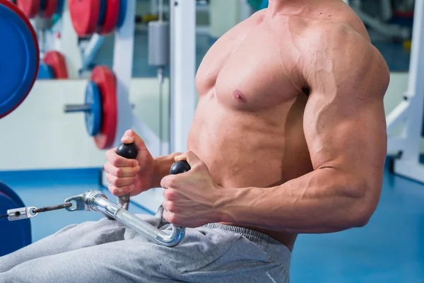 Forte uomo muscolare che fa esercizi in palestra . — Foto Stock