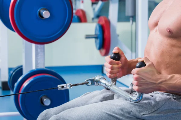 Starker muskulöser Mann bei Übungen im Fitnessstudio. — Stockfoto