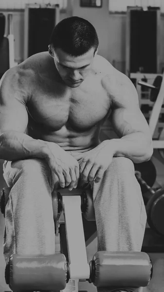 Strong muscular man doing exercises in the gym. — Stock Photo, Image