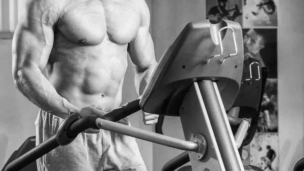 Forte uomo muscolare che fa esercizi in palestra . — Foto Stock