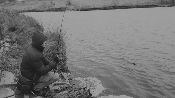 渔民在旋转的冬天钓鱼。年轻的渔夫在冬季捕捉, 运动钓鱼, 健康的生活方式, 休闲, 自然. — 图库照片