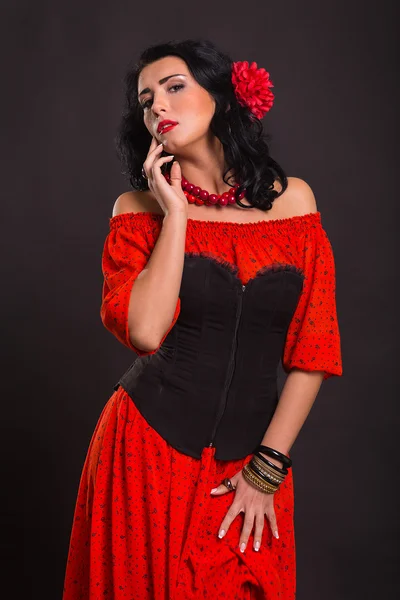 Bilden, chic, sexig Spanjor. Chic, sexig kvinna i en röd klänning. Porträtt av vacker brunett i rött i studion. Känslomässiga porträtt. — Stockfoto
