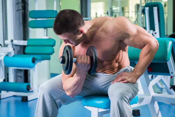 Spor salonunda yakışıklı, atletik, kendine güvenen adam. vücut geliştirme poz