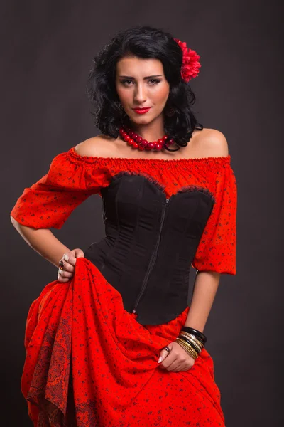 Görüntü, şık ve seksi İspanyol. Kırmızı bir elbise şık ve seksi kadın. Güzel esmer kırmızı stüdyoda portresi. Duygusal portre. — Stok fotoğraf