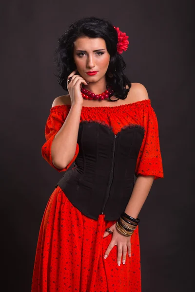 La imagen, elegante, sexy español. Mujer elegante y sexy en un vestido rojo. Retrato de la hermosa morena en rojo en el estudio. Retrato emocional . — Foto de Stock