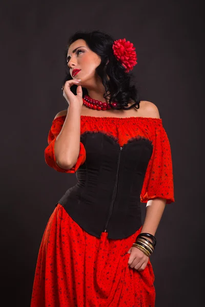Görüntü, şık ve seksi İspanyol. Kırmızı bir elbise şık ve seksi kadın. Güzel esmer kırmızı stüdyoda portresi. Duygusal portre. — Stok fotoğraf