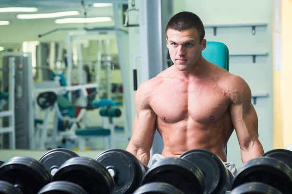 Hombre guapo, atlético y seguro en el gimnasio. postura culturismo — Foto de Stock