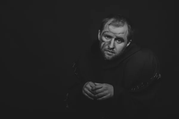 Hermoso y fascinante actor de teatro de juego en cámara. Foto en blanco y negro del actor disfrazado de mendigo sobre un fondo oscuro. Imagen escénica bellamente decorada y maquillaje profesional . — Foto de Stock