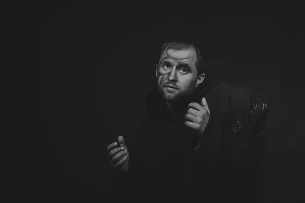 Magnifique et fascinant acteur de théâtre de jeu à la caméra. Photo en noir et blanc de l'acteur déguisé en mendiant sur un fond sombre. Image de scène magnifiquement décorée et maquillage professionnel . — Photo