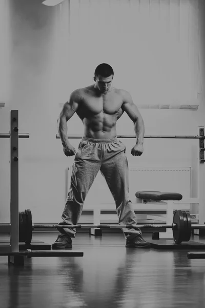 A man performs an exercise with a barbell. — Stock Photo, Image