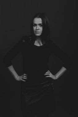 Karanlık bir arka plan üzerinde güzel, gizemli, şirin esmer. Siyah ve beyaz fotoğraf güzel gizemli esmer.