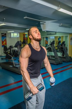 Adam jimnastik salonu. Egzersiz halter kılıyor. Spor, güç, halter, gerginlik, egzersiz - sağlıklı bir yaşam tarzı kavramı. Fitness ve spor hakkında makale.
