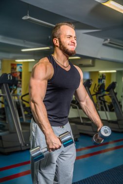 Adam jimnastik salonu. Egzersiz halter kılıyor. Spor, güç, halter, gerginlik, egzersiz - sağlıklı bir yaşam tarzı kavramı. Fitness ve spor hakkında makale.