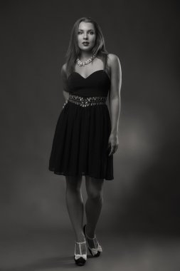 Karanlık bir arka plan üzerine bir güzel şık elbiseli baştan çıkarıcı esmer.