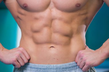 Spor salonunda yakışıklı, atletik, kendine güvenen adam. Vücut geliştirme poz gösterir.