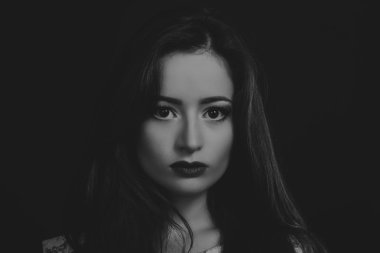 Karanlık bir arka plan üzerinde şık elbiseli çekici esmer.