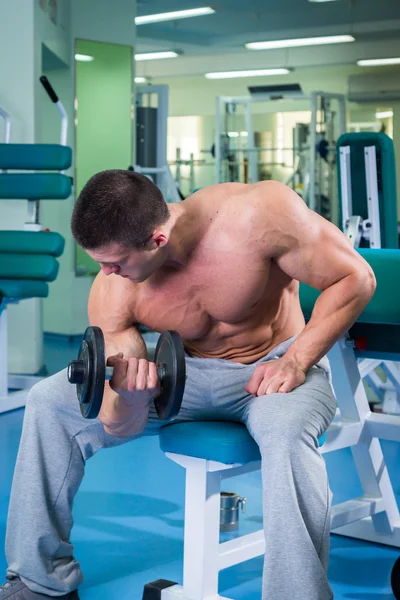 Spor salonunda yakışıklı, atletik, kendine güvenen adam. vücut geliştirme poz