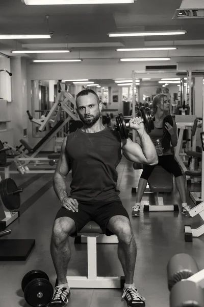 El hombre hace ejercicios para bíceps en el gimnasio . — Foto de Stock