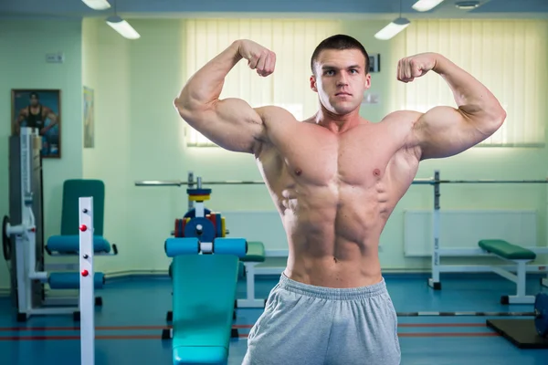 Beau, athlétique, confiant dans la salle de gym. pose de musculation — Photo